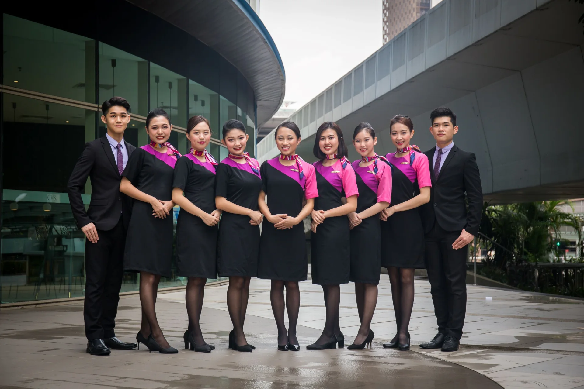 A group of cabin crew candidates in uniform posing together outside
