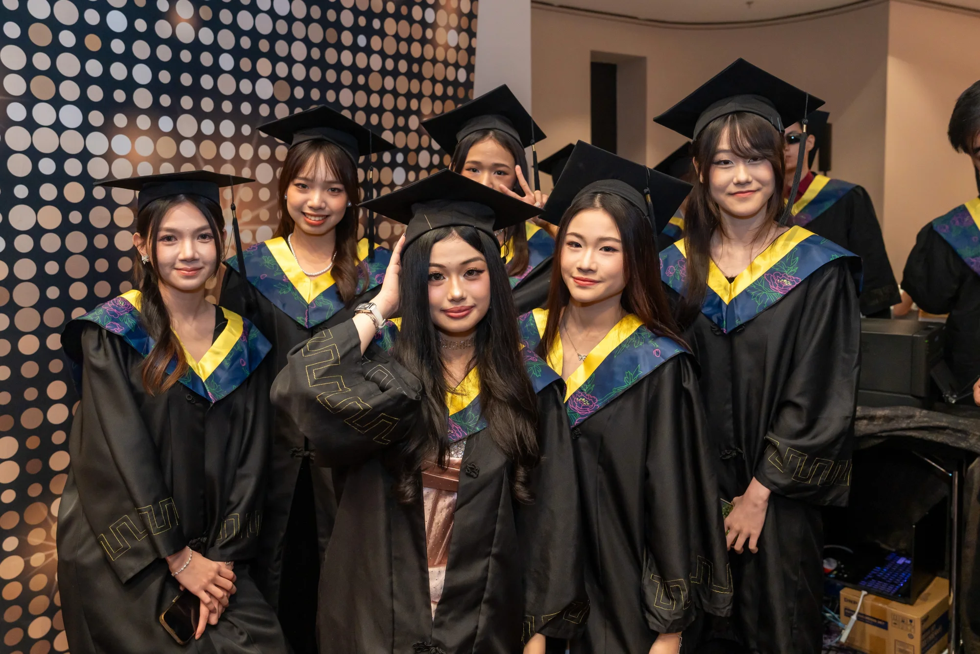 IETA graduates gathered in black gowns and blue-and-gold stoles