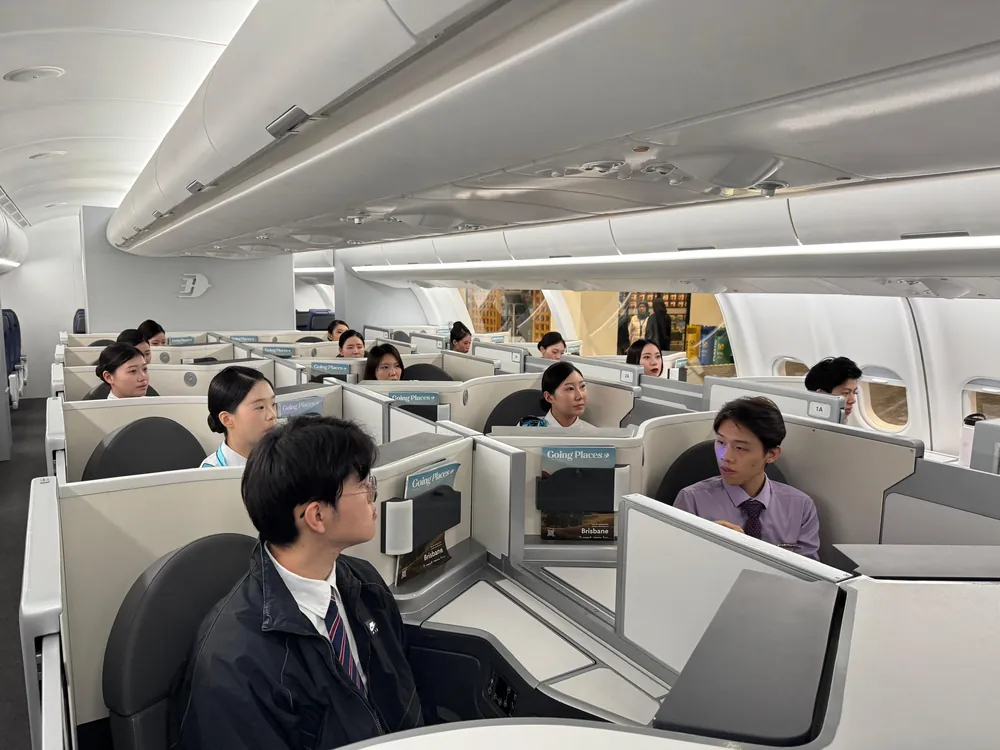 Students seated in the premium cabin of an aircraft during a training visit
