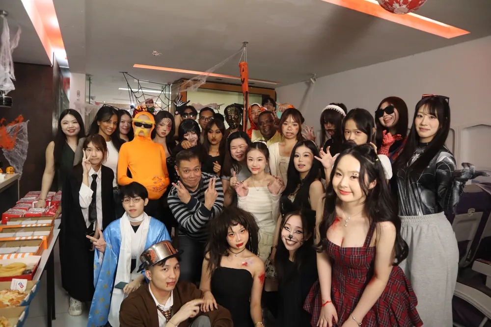 Students in costume at a social event, with food tables set up alongside