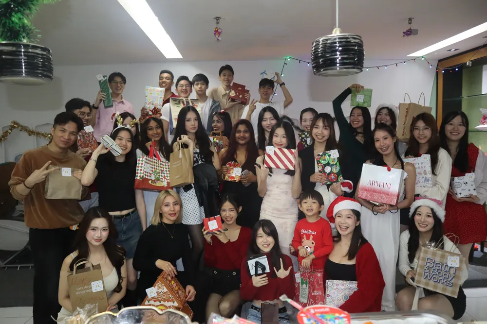 Students at a festive party holding gift bags