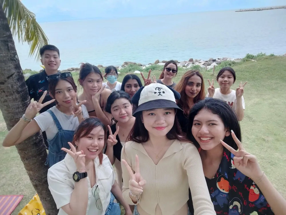Students posing together on a beach