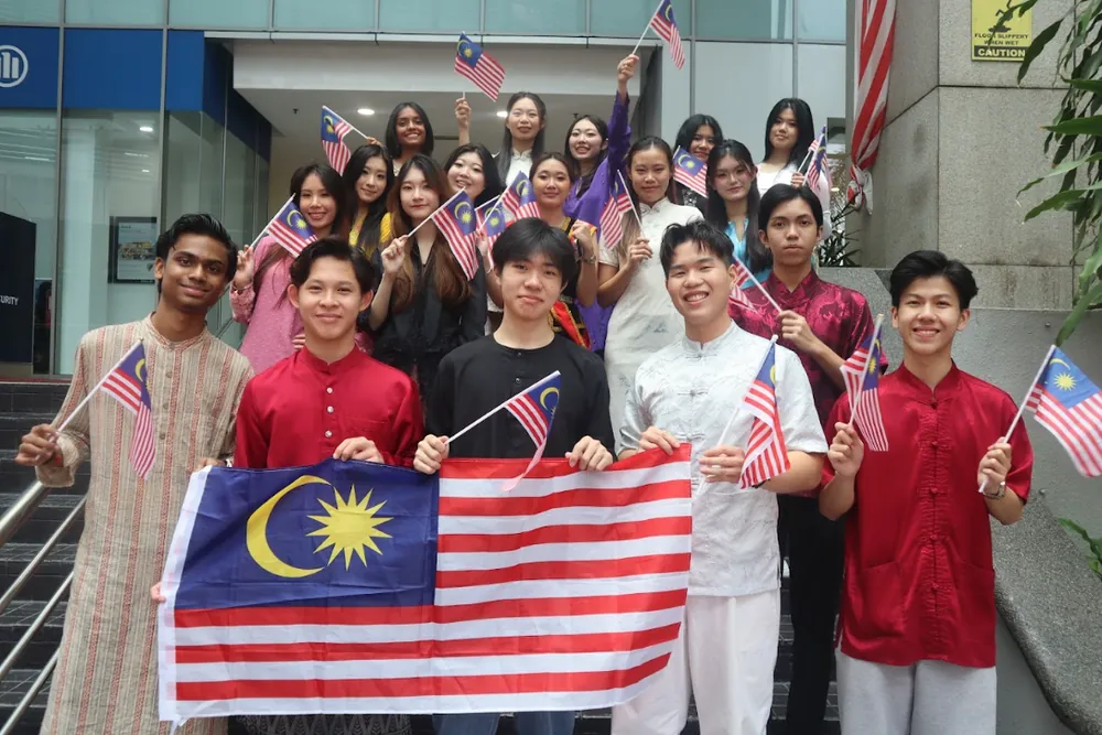 Students holding Malaysian flags at an academy event