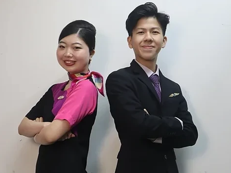 A woman in a cabin crew uniform and a man in business attire posing together